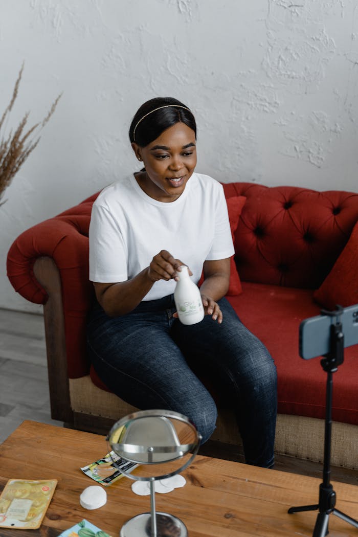 Woman recording a beauty product review for social media at home.